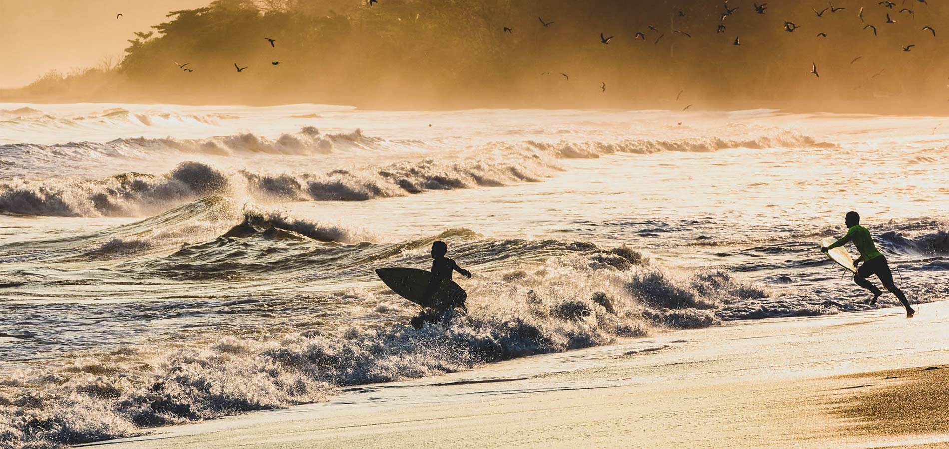 Panama beach with two surfers entering the water