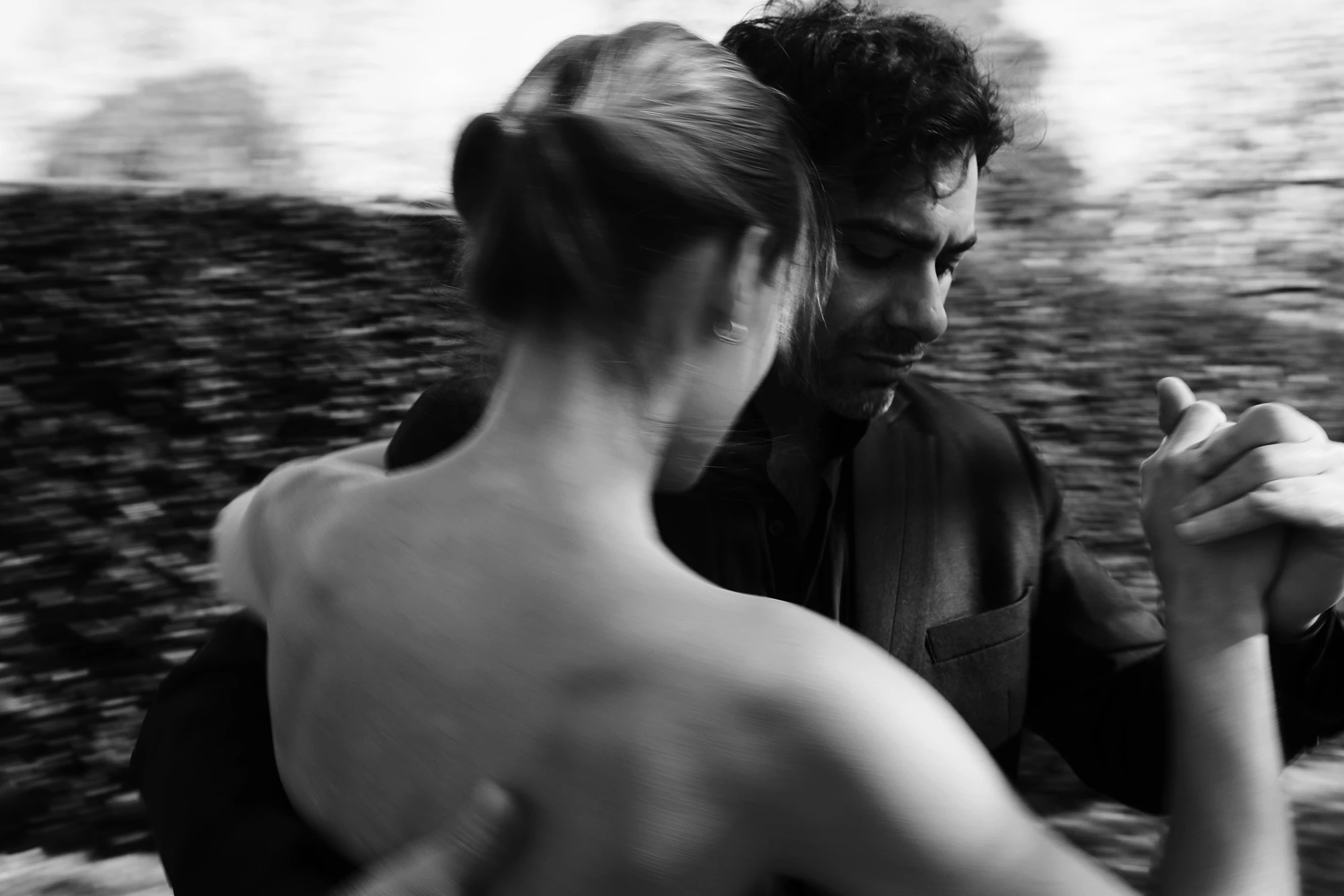 Black-and-white photograph of two tango dancers mid-step
